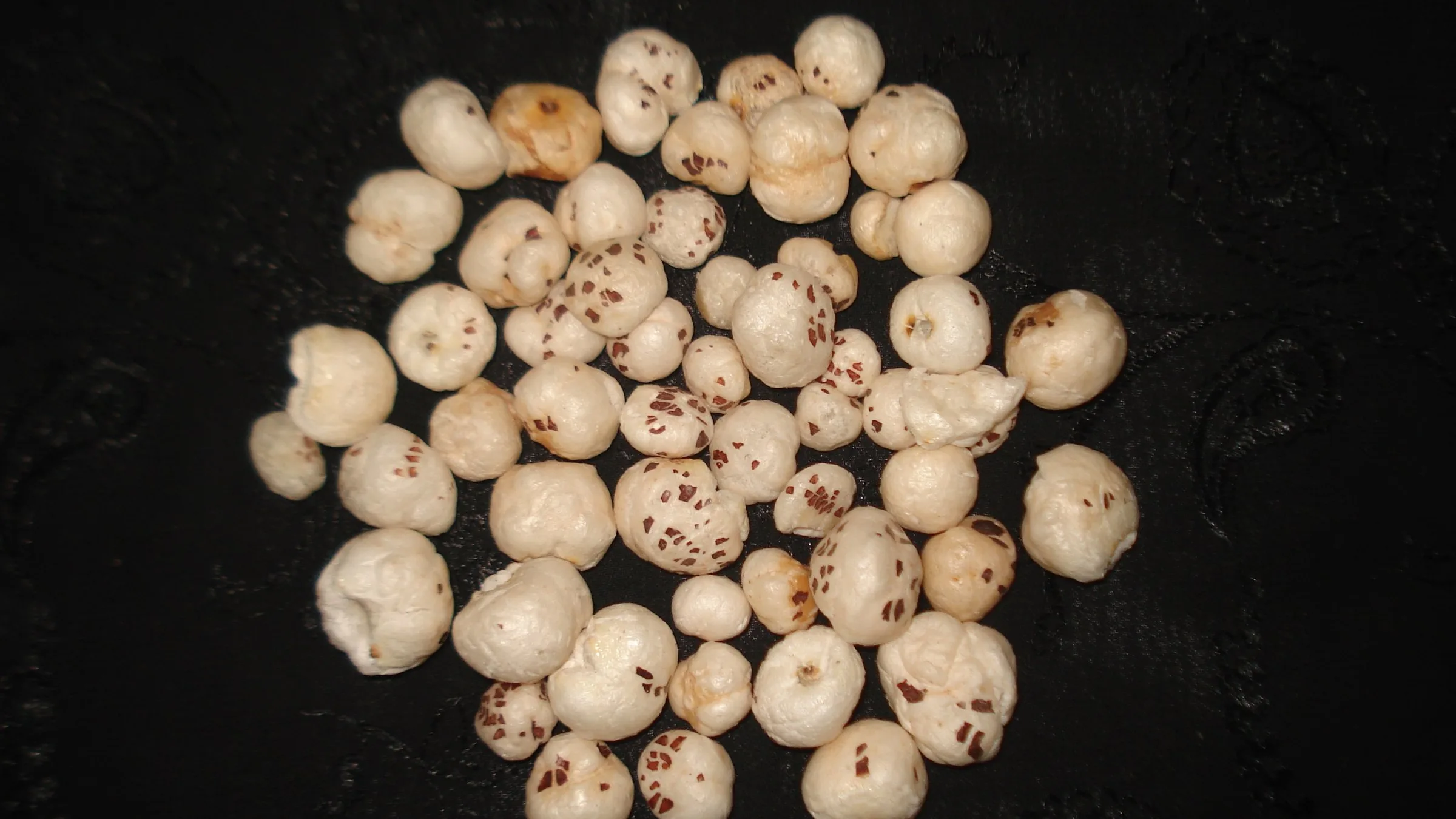 Popped makhana kernels on a dark background